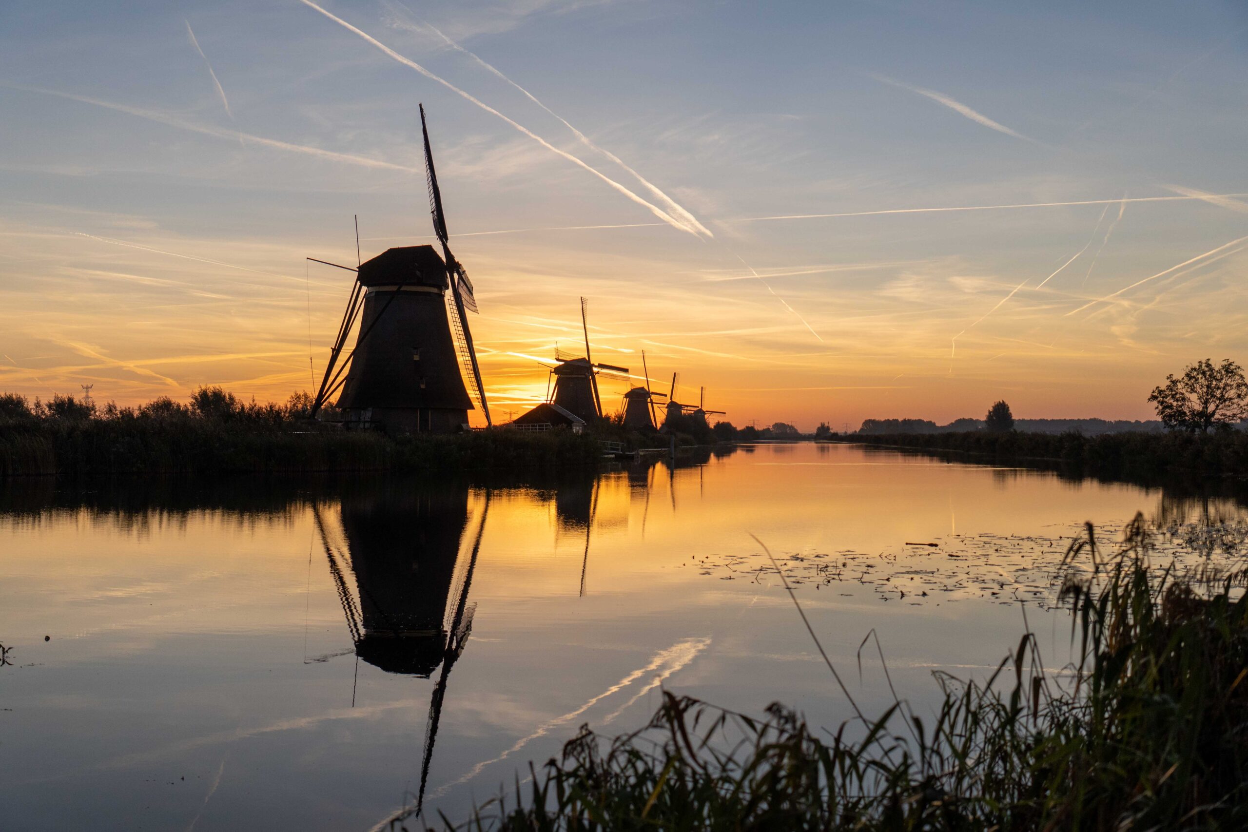 Unesco werelderfgoed windmolens aan het water bij zonsopgang