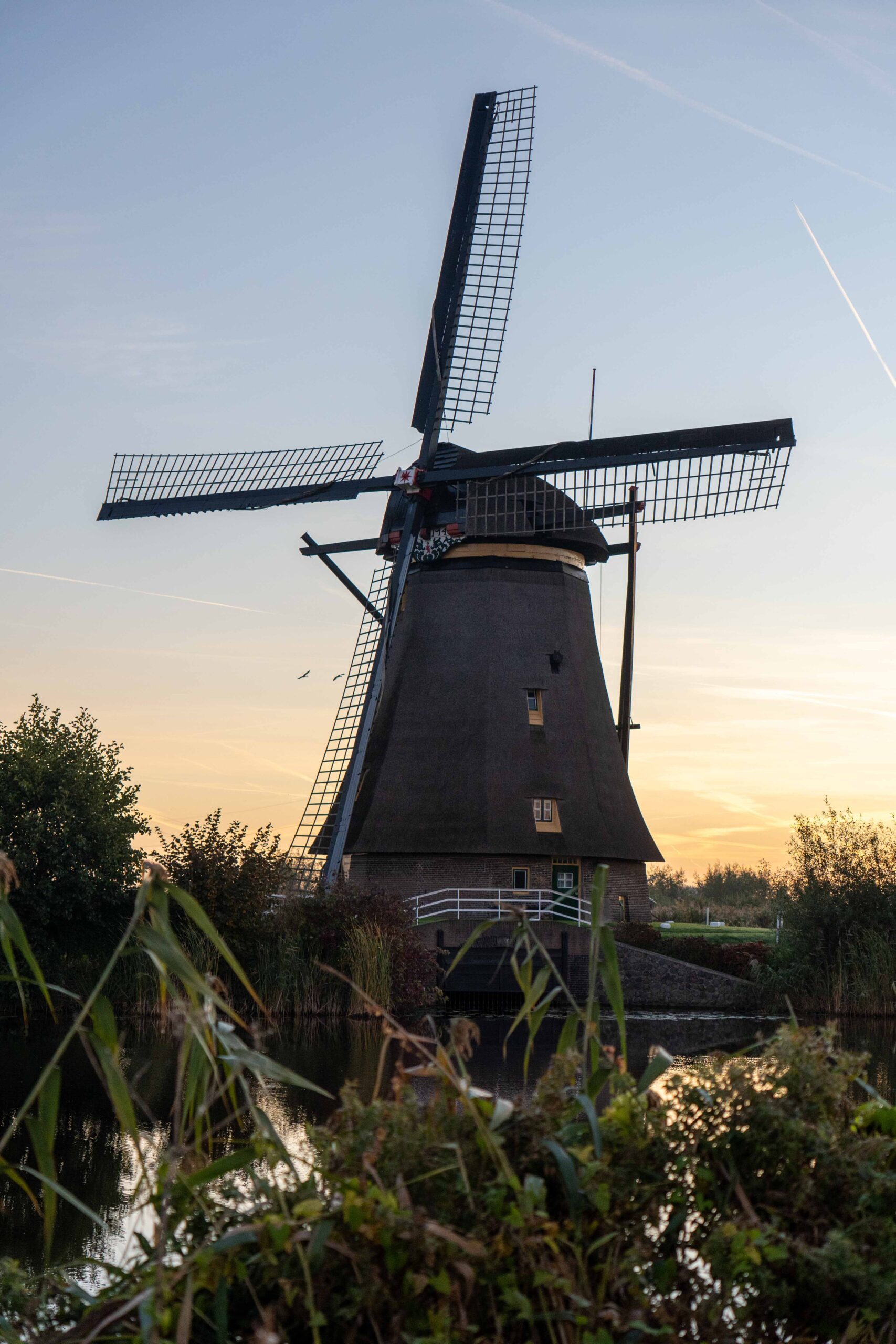 Unesco werelderfgoed windmolen aan het water bij zonsopgang