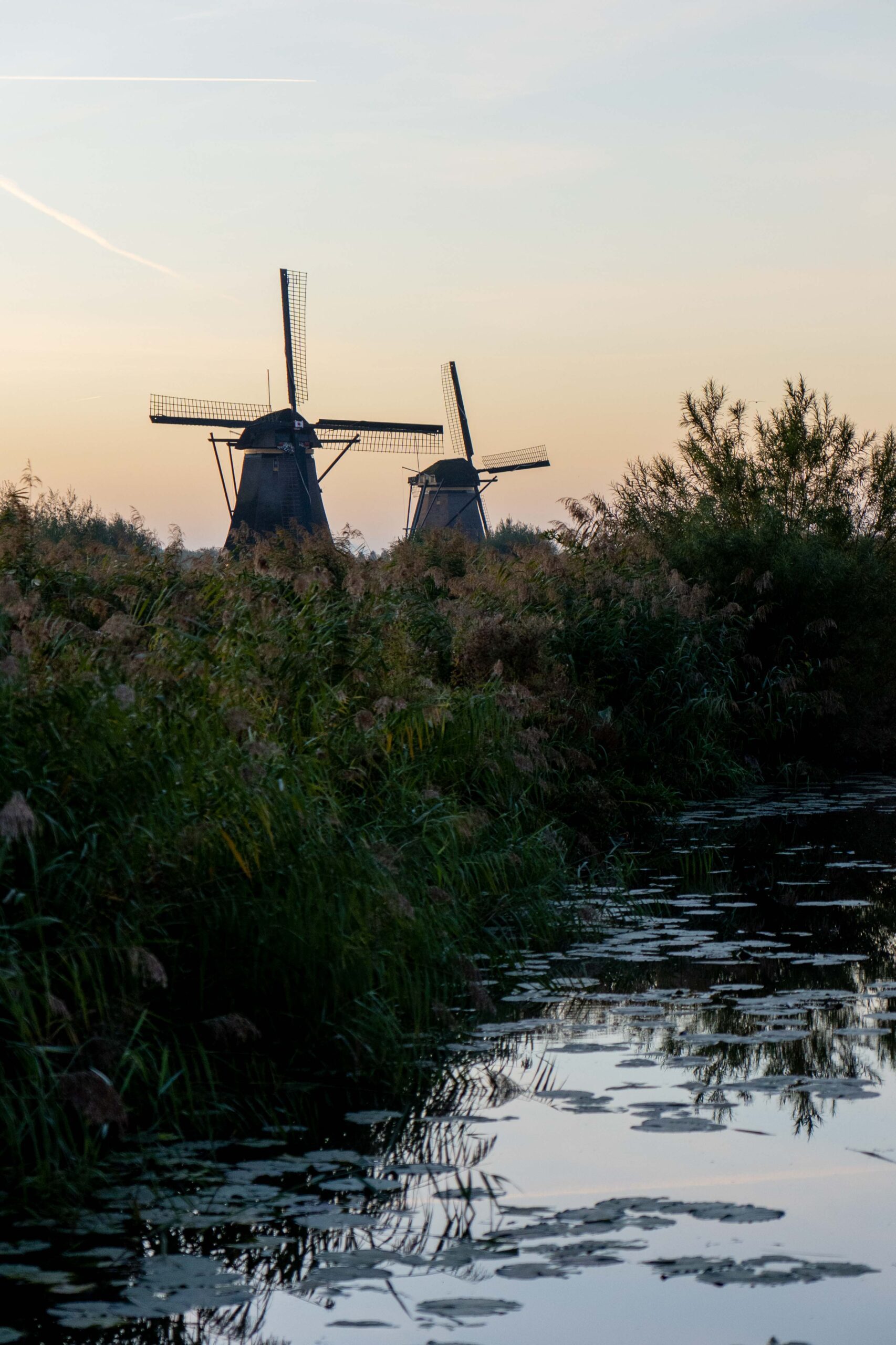 Unesco werelderfgoed windmolen aan het water bij zonsopgang