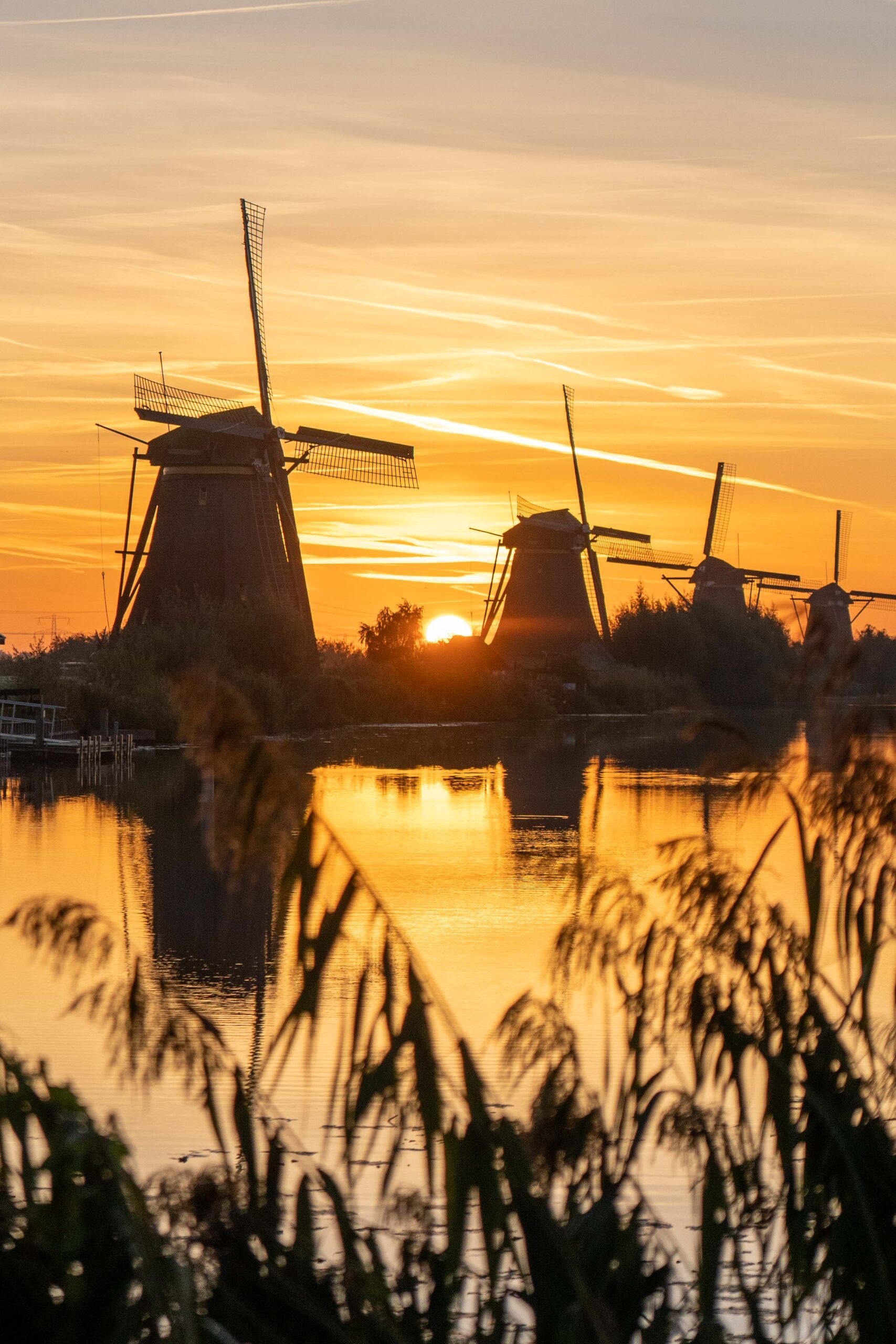 Unesco werelderfgoed windmolen aan het water bij zonsopgang